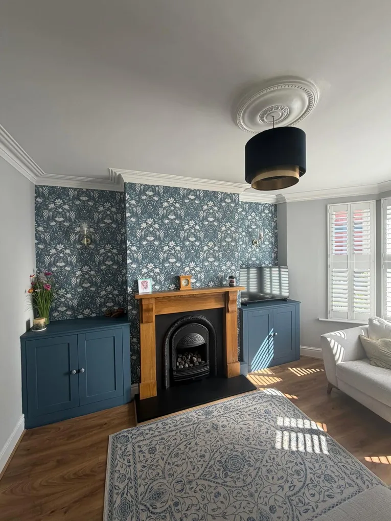 Built-in alcove cabinets either side of a chimney breast, painted dark blue